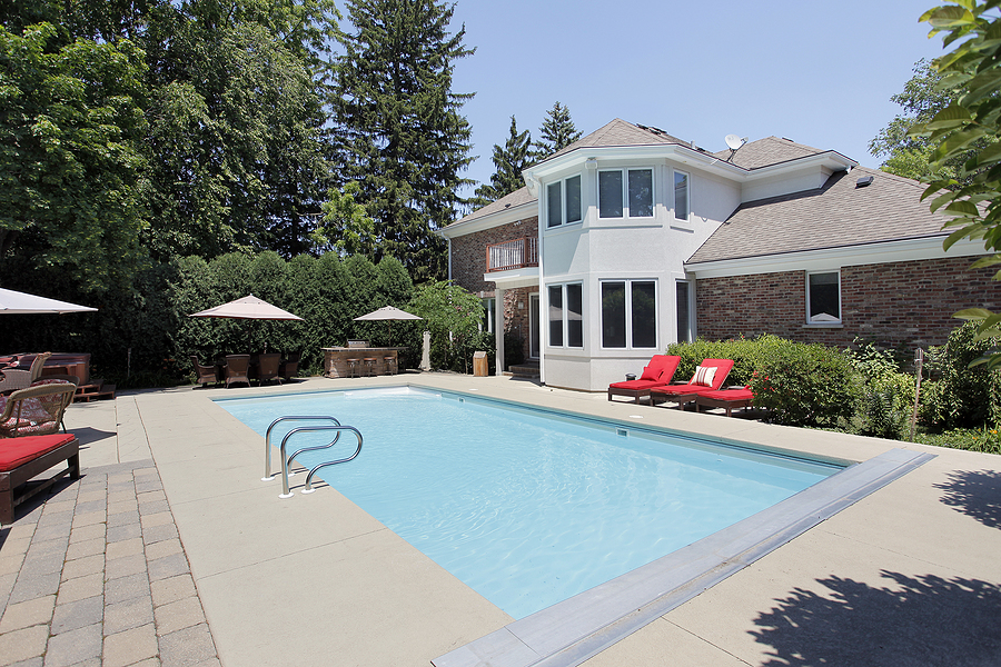 a really wide swimming pool with a concrete brick pathway